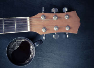 Coffee and guitar on wooden table. (Vintage Style)