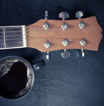 Coffee and guitar on wooden table. (Vintage Style)